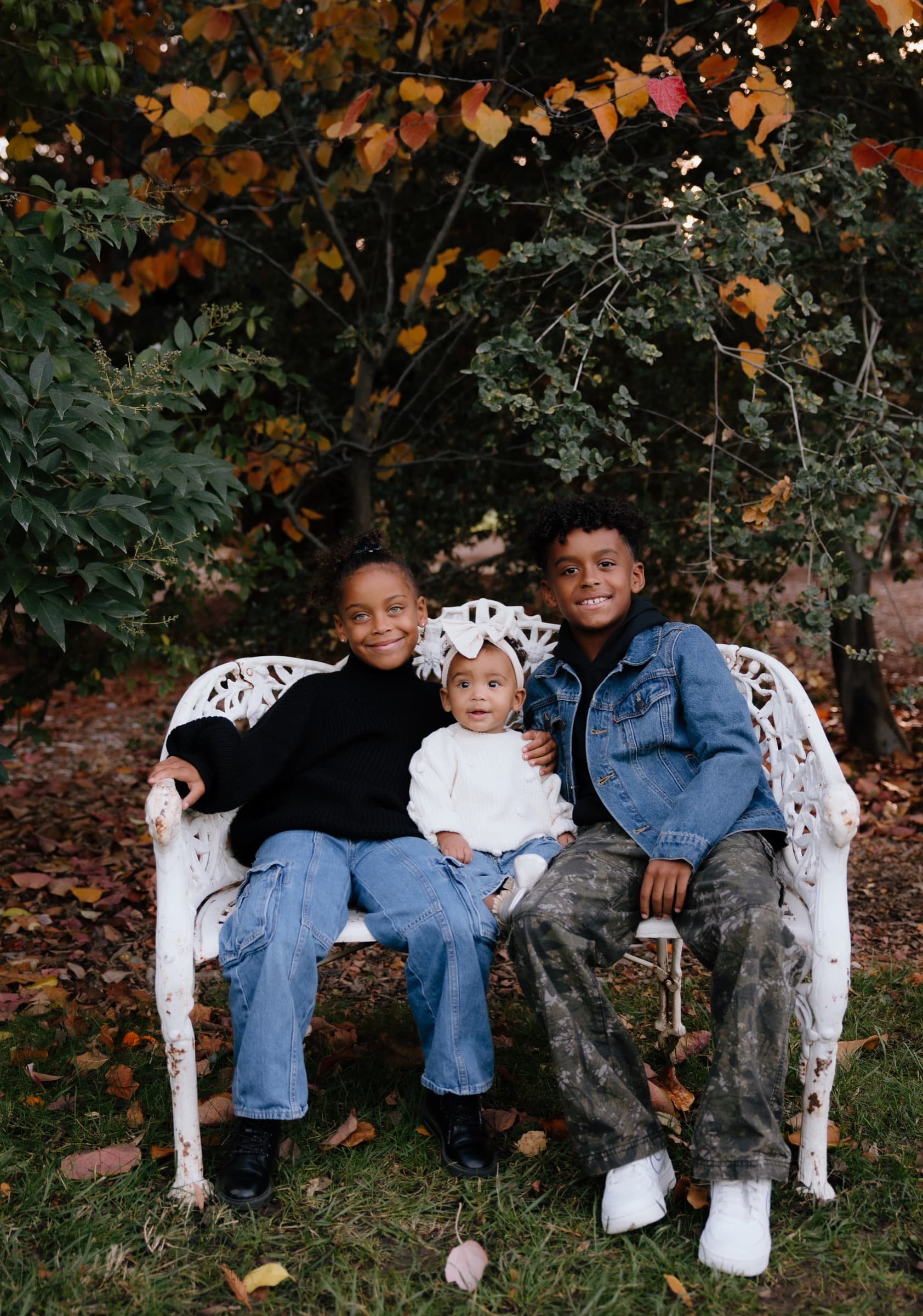 Jaiye, Kemi, and Sadé, the Sobomehin children, on a bench in autumn